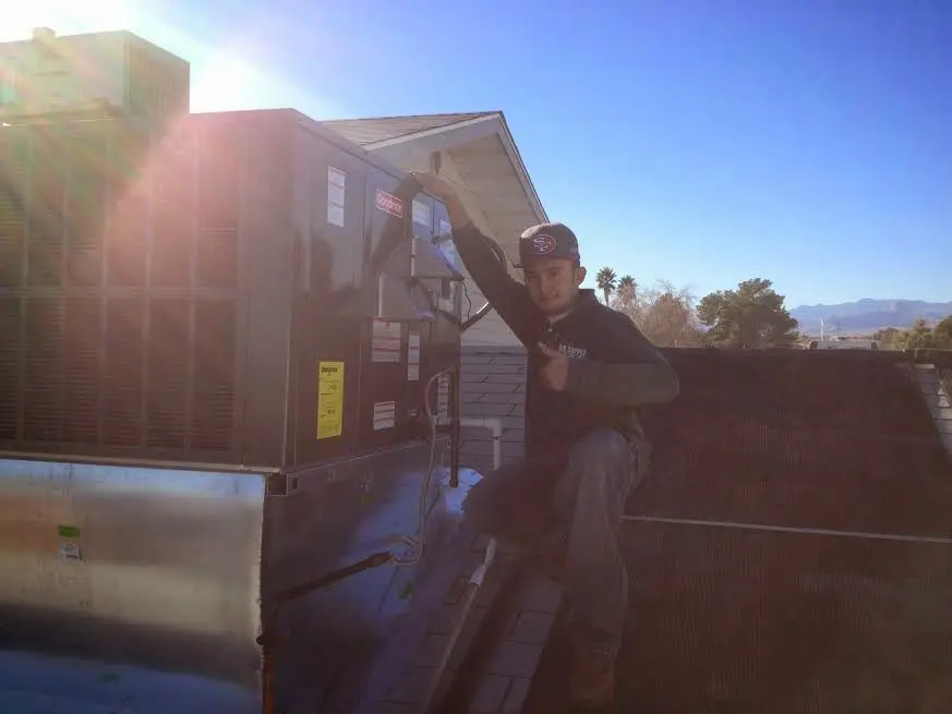 HVAC technician performing AC Tune-Up on a rooftop unit in Cedar Hill